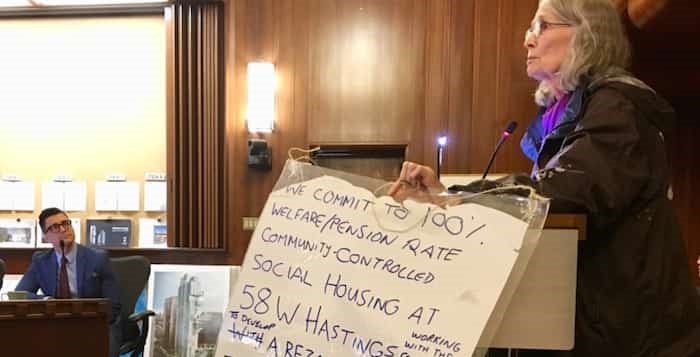  Jean Swanson, before she was a councillor, holds a poster-sized pledge that former Mayor Gregor Robertson signed on Aug. 2, 2016, to have the 231-unit building at 58 West Hastings rent at pension and welfare rates. She produced it at the public hearing where the project was approved. Photo Mike Howell