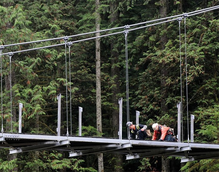  Surespan contractors work on the bridge deck for the new suspension bridge over the Seymour River in North Vancouver. photo Mike Wakefield