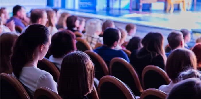  The audience in the theatre watching a play.