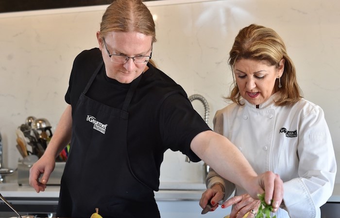  Caren McSherry is celebrating 40 years as a cooking instructor in Vancouver. She recently gave Courier reporter John Kurucz a quick lesson. Photo Dan Toulgoet