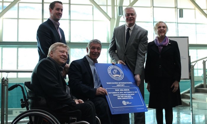  Richmond's Rick Hansen and (centre) presents YVR's Craig Richmond with a plaque recognizing its 