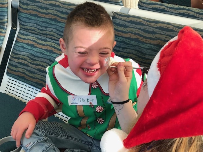  Blake Devisser, 10, gets his face painted as he waits to board the annual Flight with Santa Claus. Photo Jessica Kerr