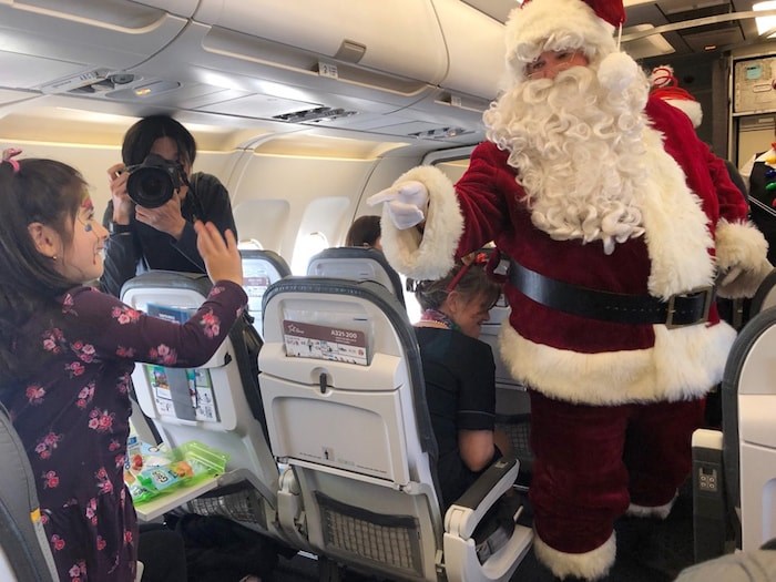  Aria Tejani, 4, shares a moment with Santa Claus as he makes his was through the plane. Photo Jessica Kerr