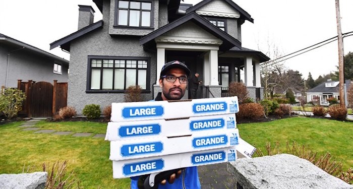  A pizza delivery man delivers pizza to the media after being instructed to do so by people inside of Huawei chief financial officer Meng Wanzhou's home in Vancouver on Wednesday, December 12, 2018. THE CANADIAN PRESS/Jonathan Hayward