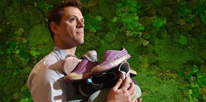  Kyle Housman, president of Vancouver-based Native Shoes, with an armful of shoes ready to be recycled at the company’s Gastown store. The ground up shoes will get a new life as safety flooring for new playgrounds around the city. Photo Dan Toulgoet