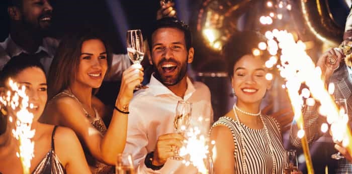  Cropped shot of young friends holding sparklers at a party / Shutterstock