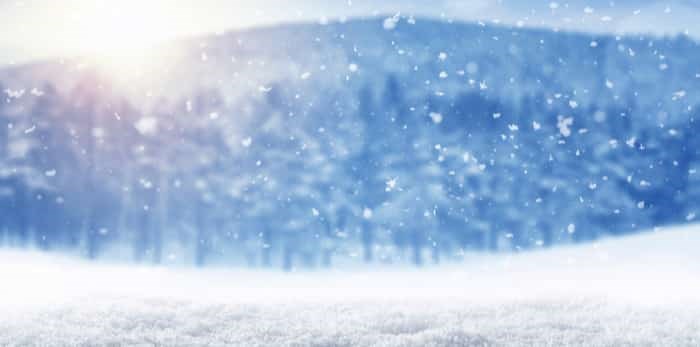  Winter background, falling snow over winter landscape with copy space / Shutterstock