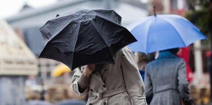  people walking with umbrellas in a rainy city / Shutterstock