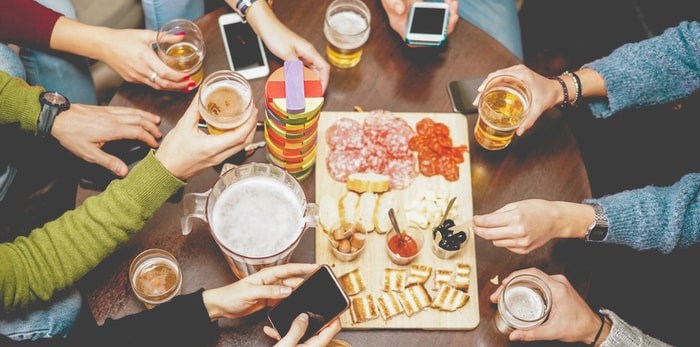  Friends dining out with cellphones/Shutterstock