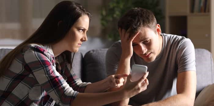  man and woman looking at cellphone / Shutterstock