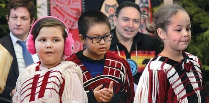  Minister of Education Rob Fleming and Assembly of First Nations National Chief Perry Bellegarde watch Wednesday as students of the Squamish Nation’s Xwemelch’stn Etsimxwawtxw (Capilano Little Ones) School perform a welcoming song to celebrate the signing of a new First Nations education agreement. photo Paul McGrath, North Shore News