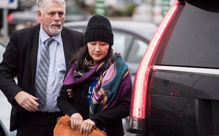  Huawei chief financial officer Meng Wanzhou, right, arrives at a parole office with a member of her private security detail in Vancouver, on Wednesday December 12, 2018. THE CANADIAN PRESS/Darryl Dyck