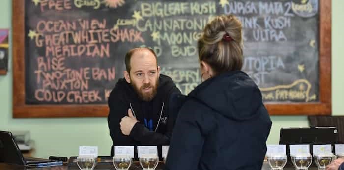  Evergreen Cannabis dispensary employee Stephen Lebovitis helps a customer on a Friday afternoon in late January.