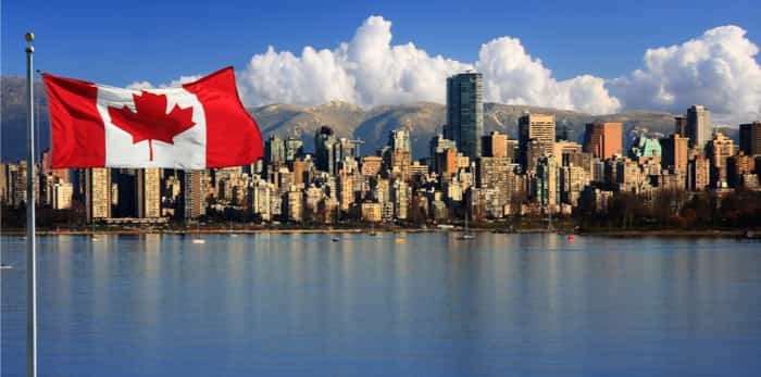  Canadian flag in front of the beautiful city of Vancouver / Shutterstock