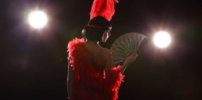  Burlesque dancer with red plumage and red short dress / Shutterstock