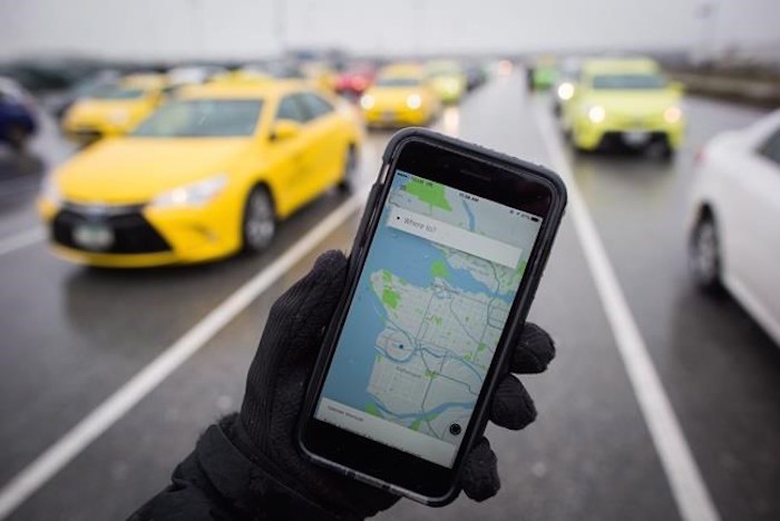  The Uber app is displayed on an iPhone as taxi drivers wait for passengers at Vancouver International Airport, in Richmond, B.C., on Tuesday March 7, 2017. The federal Competition Bureau wants British Columbia to re-examine its taxi regulations to permit more competition in the industry and improve services for riders and businesses. THE CANADIAN PRESS/Darryl Dyck