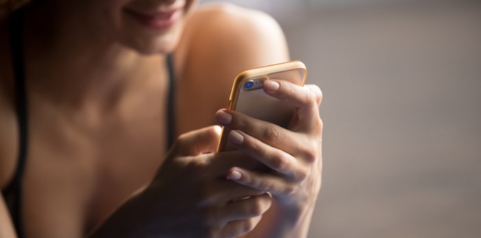  Woman looking at cellphone/Shutterstock