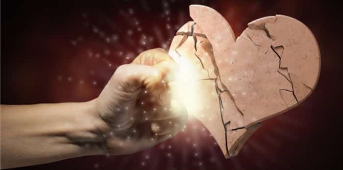  Photo: Close up of human hand breaking stone heart / Shutterstock
