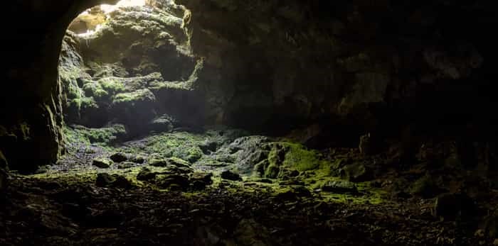  Dark cave with a bright daylight spot of exit / Shutterstock