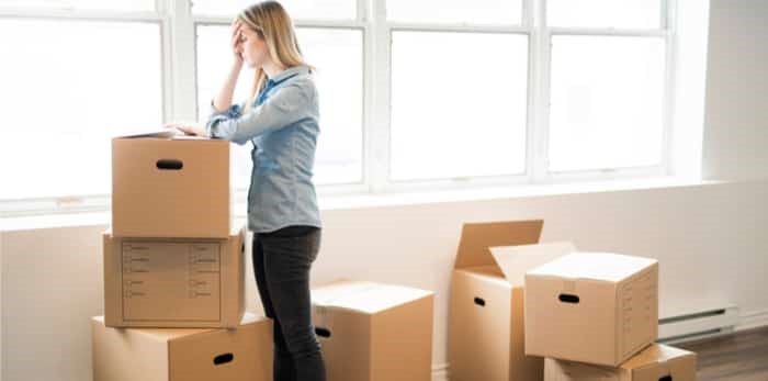  Woman frustrated, surrounded with boxes on a lonely move / Shutterstock