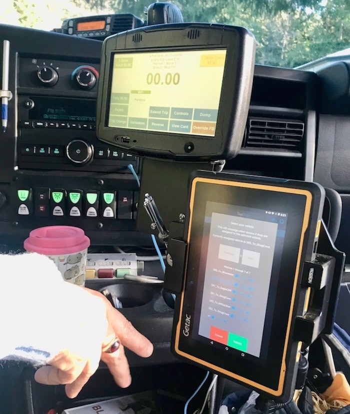  Bus driver Pam Mitts fiddles with the tablet that’s the drivers’ side of TransLink’s new TapRide mobile app for Bowen buses. Photo by Bronwyn Beairstro