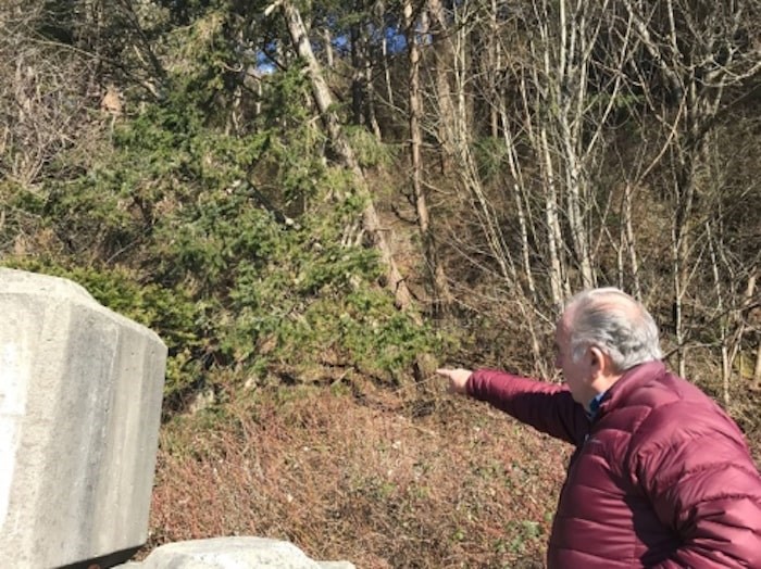  Jim Northey points toward the runoff pipe from the neighbouring subdivision above. Photo by Sandor Gyarmati