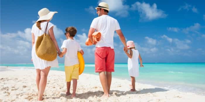  Back view of a happy family on tropical beach / Shutterstock