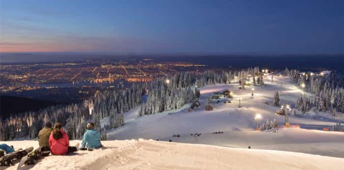  skier and snowboarder waiting for sunrise on Grouse Mountain / Shutterstock