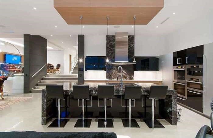  The kitchen in the great room of this split-level home is designed by European kitchen designers Poggenpohl and has black marble countertops and backsplash. Listing agent: Nafiseh Samsam