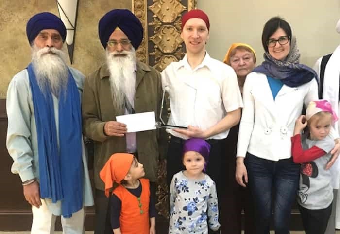  Alexey Baybuz (wearing the red head covering and holding the award) was honoured on Sunday by the the Sukh Sagar Sikh Gurdwara (temple) in Queensborough. PHOTO CONTRIBUTED