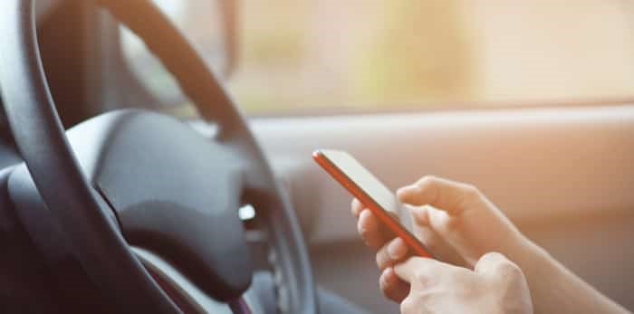  Man using mobile phone while driving a car