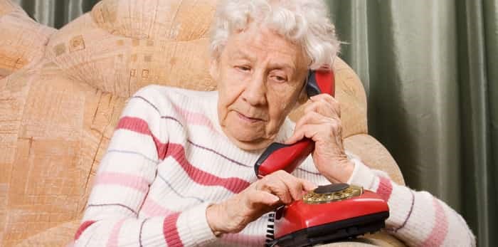  An elderly woman speaks on phone / Shutterstock