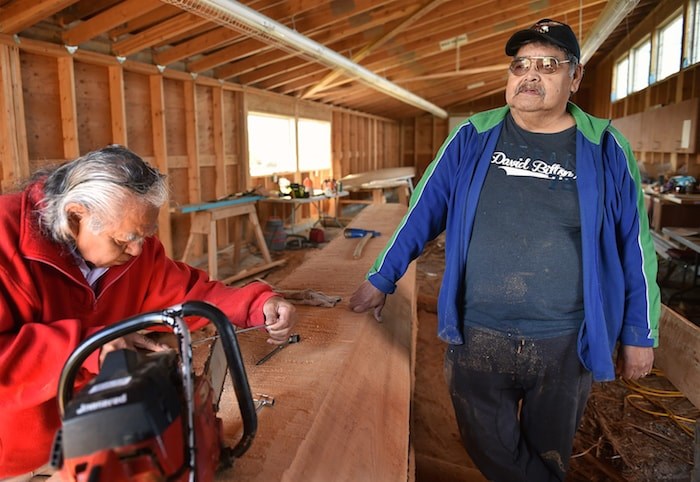  Musqueam Indian band carver William Dan, at right, works on what will become a 20-foot welcome post at the carving pavilion adjacent to Britannia secondary. Photo by Dan Toulgoet