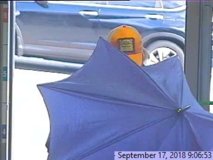  Police are loking for help identifying the umbrella bandit, a man who robbed a local bank last September while hiding from security cameras under a big, blue umbrella. Photo courtesy Burnaby RCMP