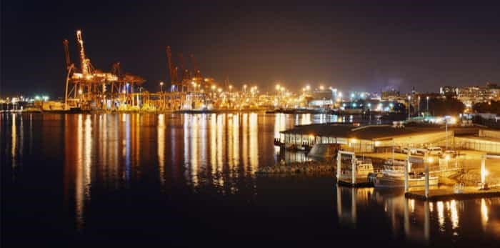  VANCOUVER, BC - AUG 17: Sea port with crane and cargo containers at night on August 17, 2015 in Vancouver, Canada / Shutterstock