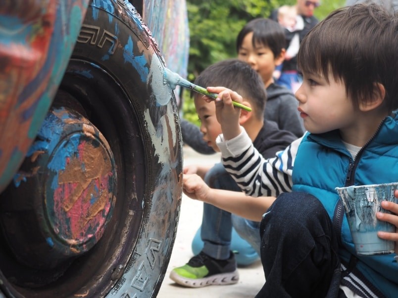  Lui Osborne, 5, decorates the wheel of a van with a clutch of other children. Photo by Stefan Labbé.