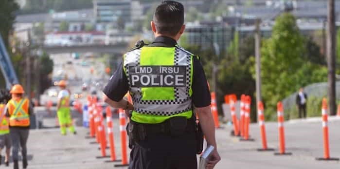  An Integrated Road Safety Unit officer watches for driving infractions in a construction zone in Burnaby Monday.