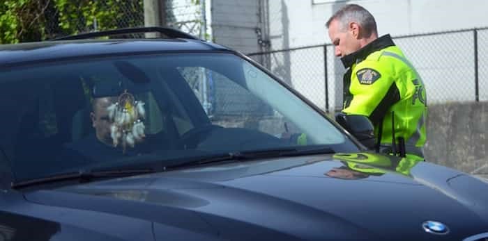  An Integrated Road Safety Unit officer writes a driver a ticket for an infraction in a construction zone in Burnaby Monday. Photo:; Cornelia Naylor