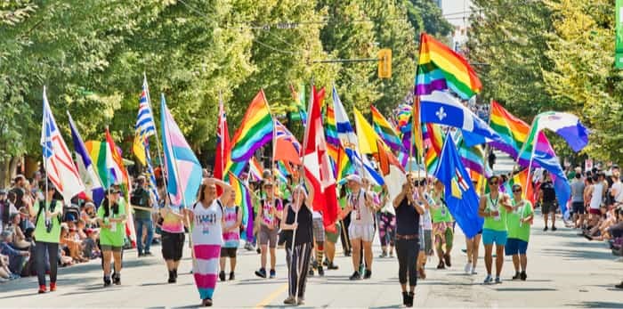  Vancouver, BC/Canada - August 5 2018 : Vancouver Pride Parade- People marching with rainbow flag / Shutterstock