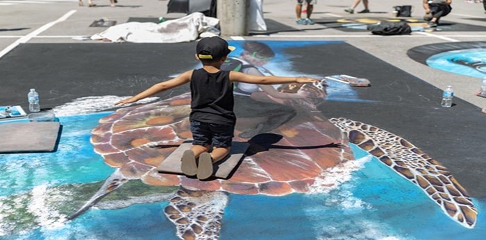  A young visitor interacts with chalk art by Wayne and Cheryl Renshaw at the 2018 Chalk Art Experience. Photo: Leanne Scherp, contributed (files)