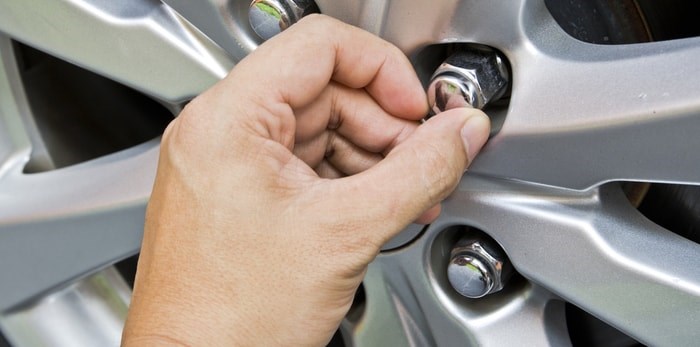  Loosening a lug nut by hand/Shutterstock