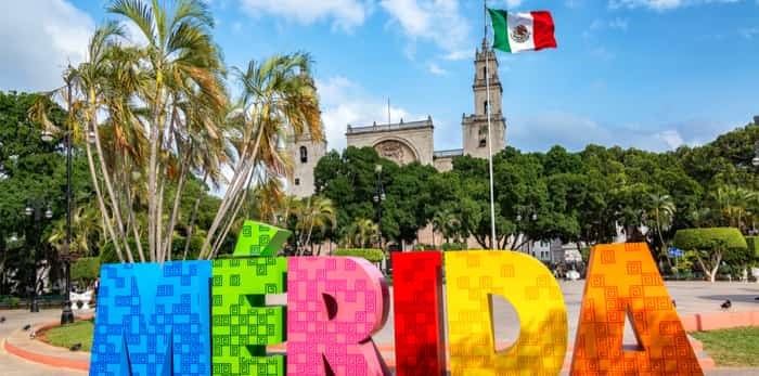  Photo: MERIDA, MEXICO - FEBRUARY 21: Colourful Merida sign with a Mexican flag and cathedral in the background in Merida, Mexico on February 21, 2017 / Shutterstock