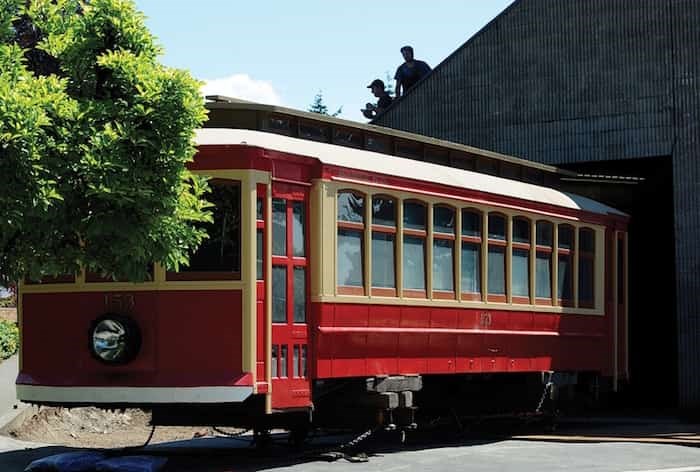  A crew from Nickel Bros. moving company inches the 111-year-old streetcar out from under the bleachers at Fen Burdett Stadium Wednesday. Photo: Mike Wakefield, North Shore News