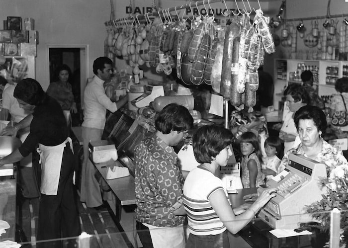  Anna Bruzzese works the cash register at the deli's original location on Commercial and First Avenue in 1977. Photo courtesy La Grotta Del Formaggio