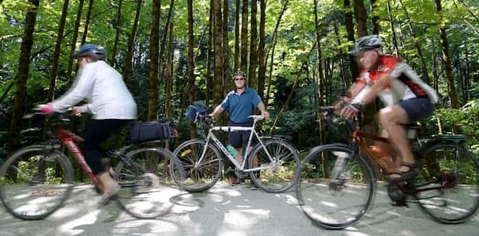  Dennis Hansen, chair of HUB Burnaby, on his favourite bike path, the Central Valley Greenway stretch along the Brunette River, as other HUB members pedal past.