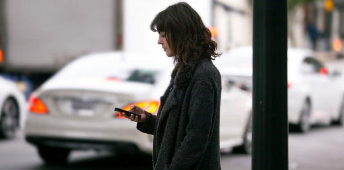  A ride-hailing customer waits for her car to pick her up/Shutterstock