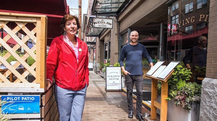  Yaletown Business Improvement Association executive director Annette O'Shea stands by the Flying Pig restaurant's curbside patio while the restaurant's co-owner, Erik Heck, looks on from his bistro's entrance. Photo by Chung Chow/Business In Vancouver