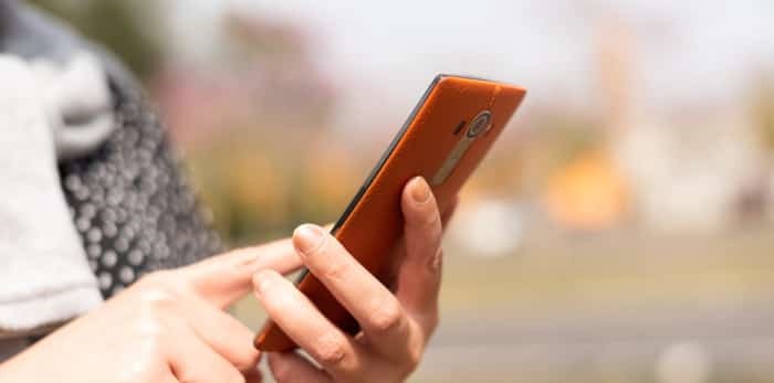  Photo: woman uses smartphone outside / Shutterstock