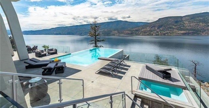  The home's infinity pool stretches out as if merging with the lake, while glass balustrades keep the view clear. Listing agent: Richard Deacon
