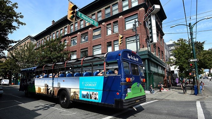  An open top tourist bus drives through the Downtown Eastside at the height of tourist season in late July. Photo: Jennifer Gauthier